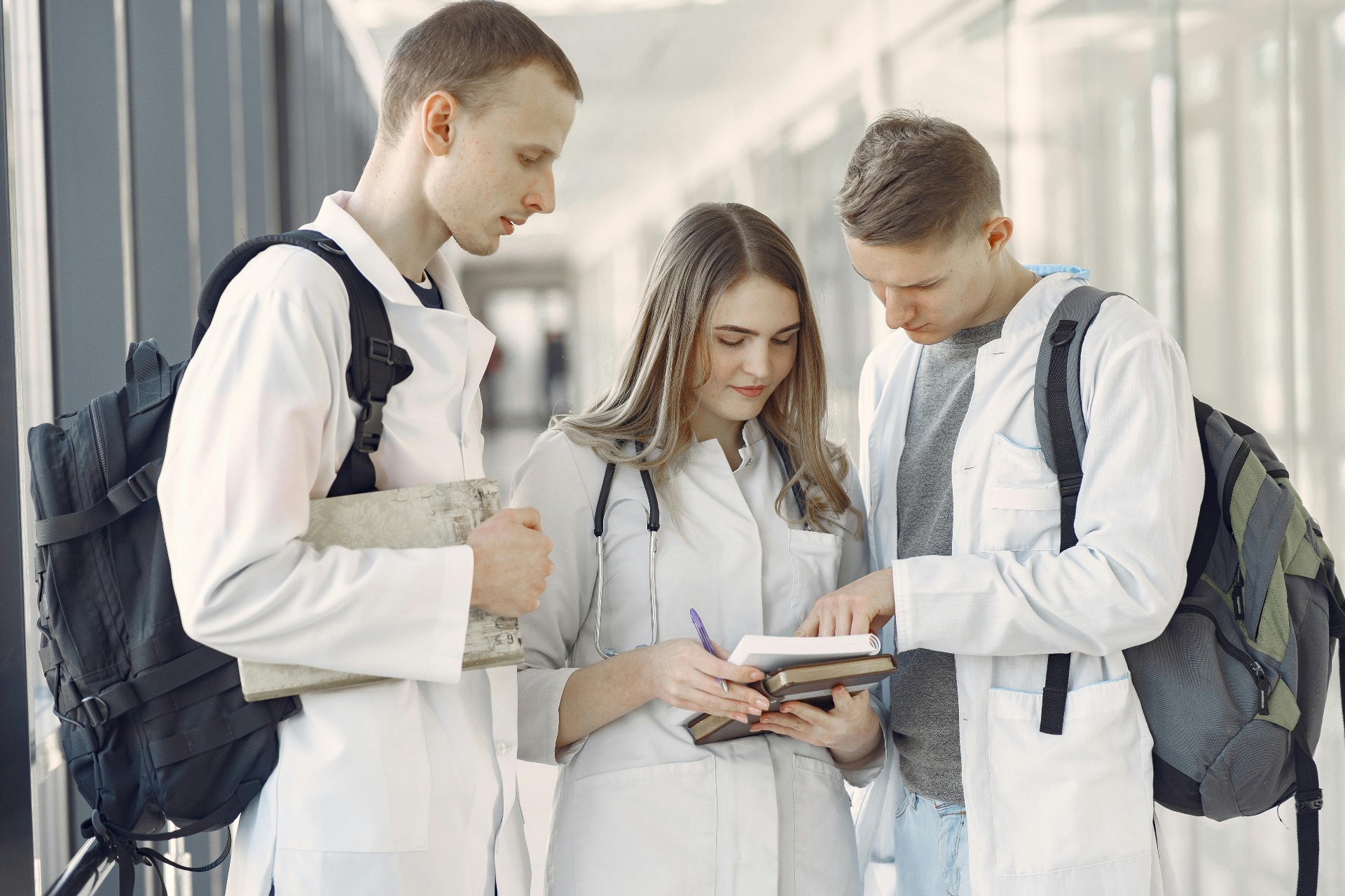 Dois estudantes de Medicina sorrindo, com jalecos brancos e estetoscópios